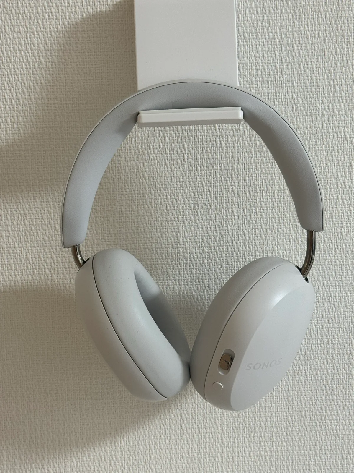 ソフトホワイトのSonos Ace。白いイヤーカップと金属部分、控えめなSONOSロゴが見える