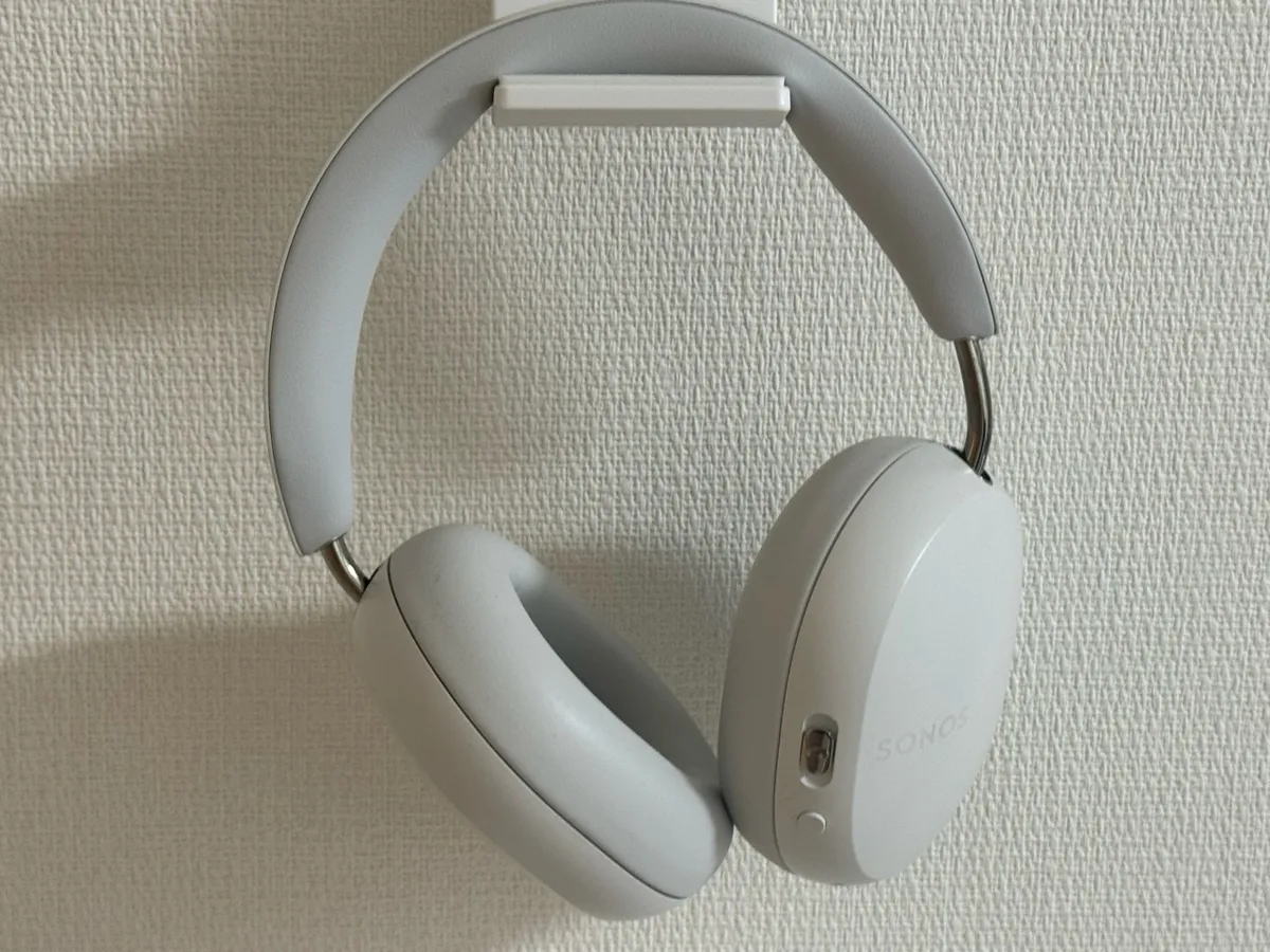 白い壁のフックに掛けたSonos Aceの全体と右側のボタン