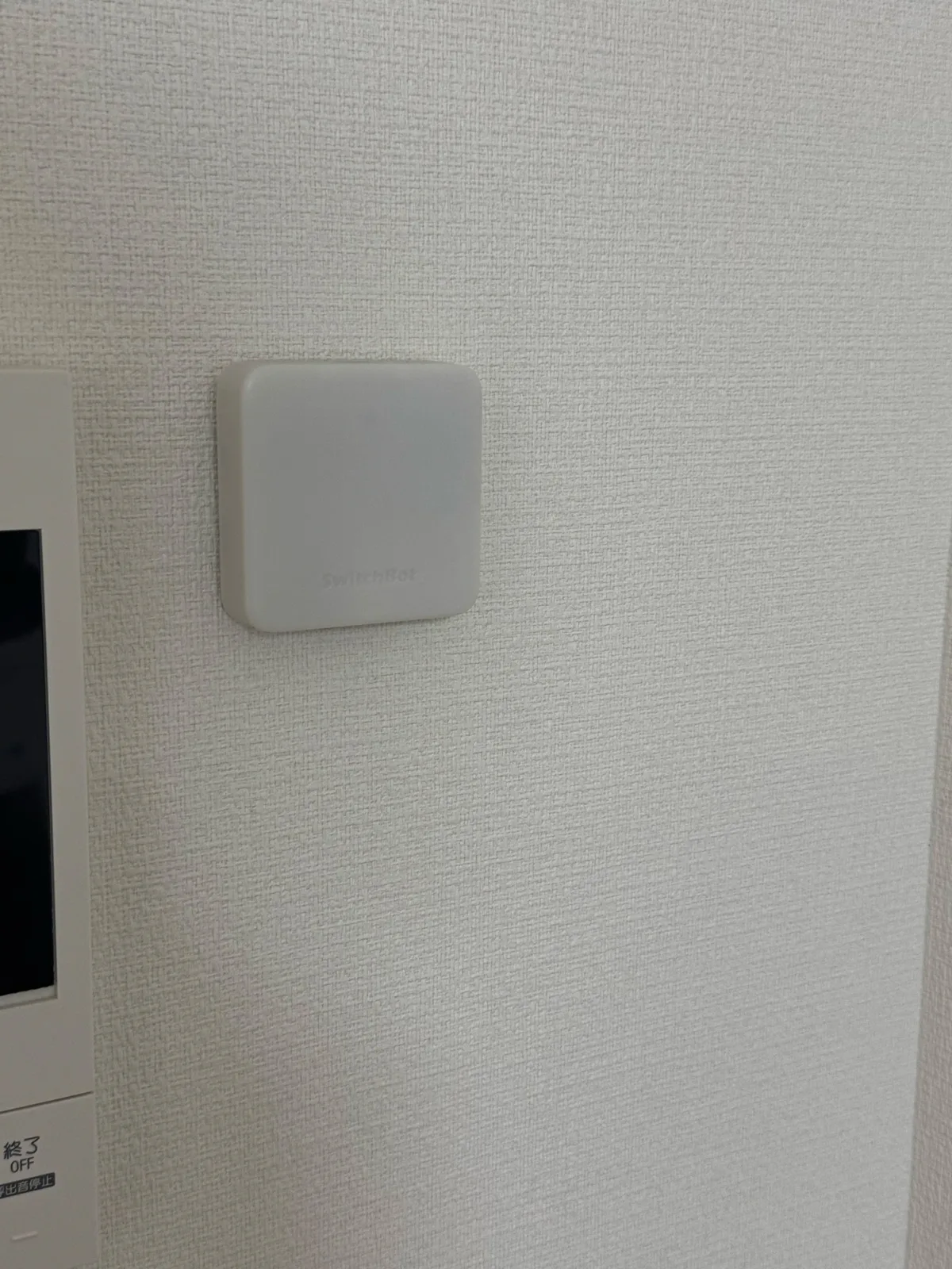 自宅の白い壁に貼って設置したSwitchBot ハブミニと周囲の様子