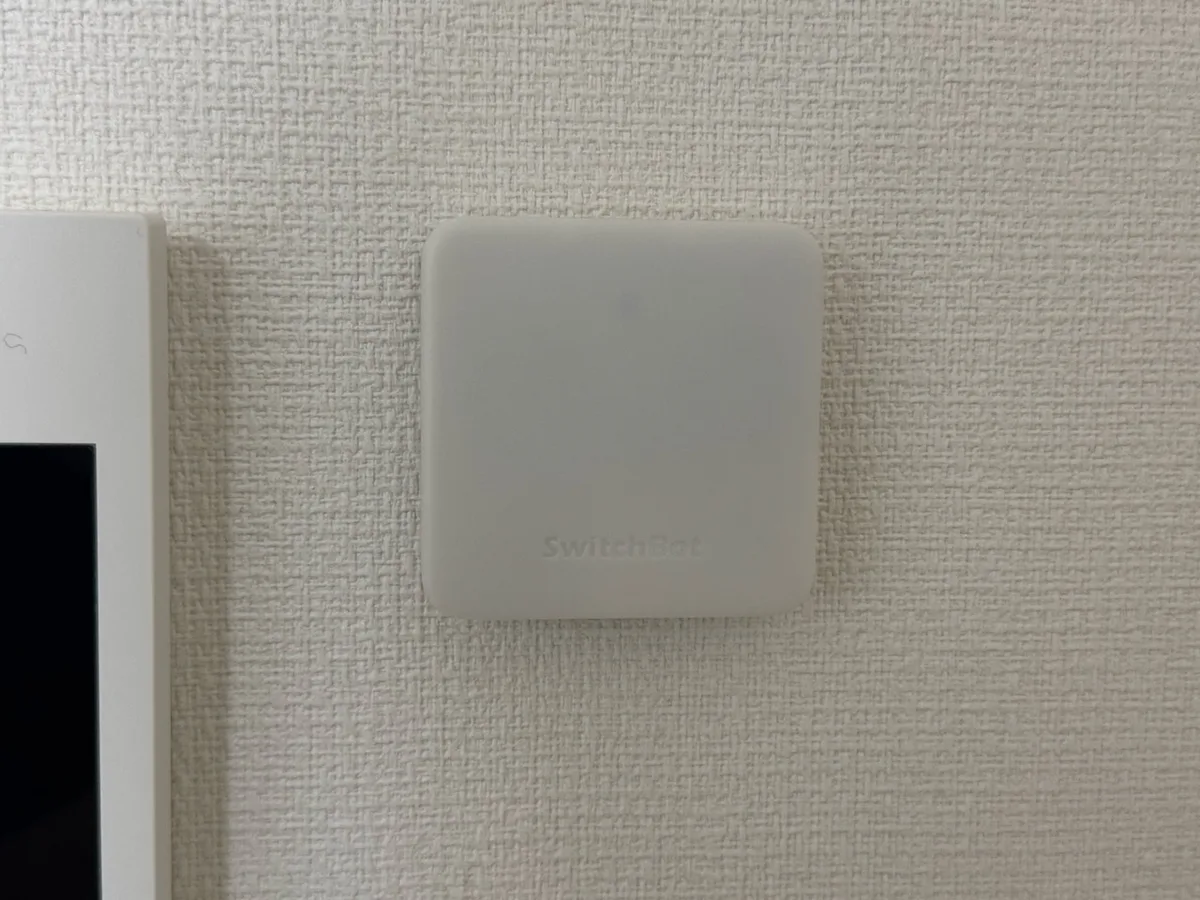 壁になじむ白いSwitchBot ハブミニを正面から撮影した様子